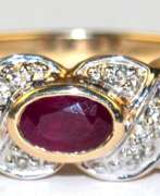 Watches & Jewelry. Ring, 585er GG/WG, besetzt mit oval facettiertem Rubin und kl. Diamanten, ges. 2,68 g, RG 56