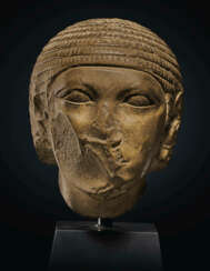 AN EGYPTIAN INDURATED LIMESTONE HEAD OF A MAN