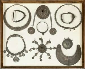 Gruppe von Schmuckstücken in Bronze und Silber, unter anderem Halsketten, Anhänger und Armreife