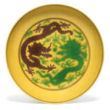 A YELLOW-GROUND GREEN AND AUBERGINE-ENAMELLED 'DRAGON' DISH ... - Foto 1