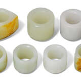 A GROUP OF SEVEN WHITE JADE AND GLASS ARCHER'S RINGS - photo 2