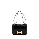 HERMÈS. A SHINY BLACK POROSUS CROCODILE CONSTANCE 23 WITH GOLD HARDWARE - фото 1