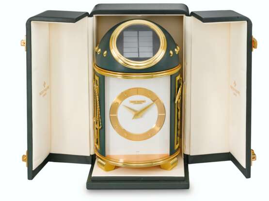 Patek Philippe. PATEK PHILIPPE, ELECTRO-MECHANICAL AND SOLAR-POWERED GILT BRASS AND GREEN LEATHER TABLE CLOCK WITH APPLIED GILT ORNAMENTS "COMMERCE ET INDUSTRIE" AND ORIGINAL FITTED BOX, REF. 714 - Foto 1