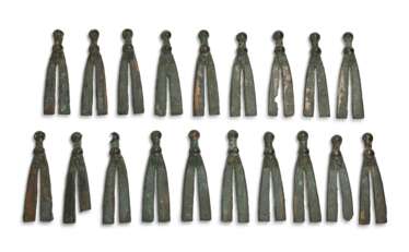 A GROUP OF THIRTY-FOUR BRONZE V-SHAPED HARNESS ORNAMENTS