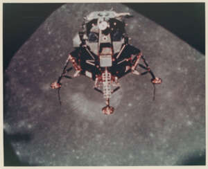 The LM Intrepid in lunar orbit; lunar horizon over Crater Copernicus at Sunrise, November 14-24, 1969