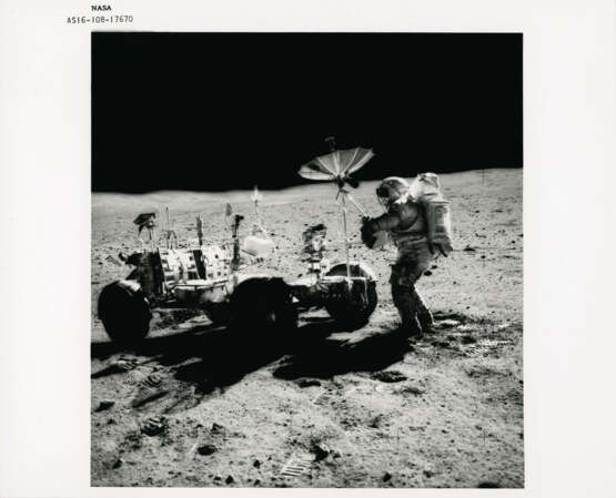 John Young pointing the Rover antenna toward Earth; TV pictures at Wreck Crater; Charles Duke hammering a double core tube, station 8, April 16-27, 1972, EVA 2 - photo 1