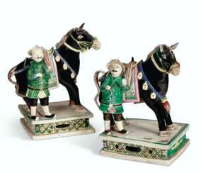 A PAIR OF BISCUIT-GLAZED ROSE-VERTE HORSES BESIDE RIDERS