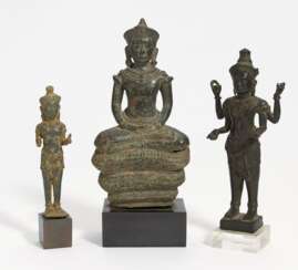 Zwei stehende Figuren und Buddha auf Schlangenthron
