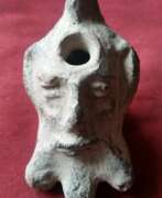 Stone. Ancient Roman clay oil lamp with head motif
