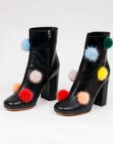 Paar schwarzer Leder Booties Pom Pom