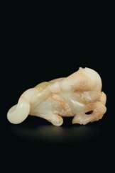 A WHITE AND PALE BROWN JADE FIGURE OF A ROLLING HORSE