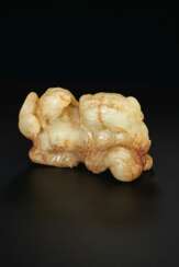 A PALE YELLOWISH-GREEN AND BROWN JADE CARVING OF A &#39;BUDDHIST&#39; LION AND ITS CUB
