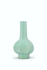 A SMALL OPAQUE GREEN GLASS FACETED BOTTLE VASE