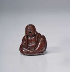 A CARVED WOOD SCULPTURE OF A SEATED DARUMA