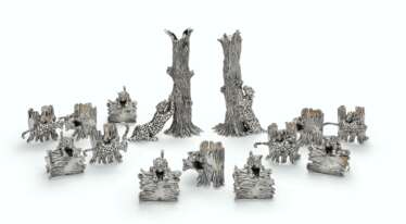 A SET OF TWELVE SILVER AND NIELLO FIGURAL NAPKIN RINGS AND A PAIR OF MATCHING CANDLESTICKS