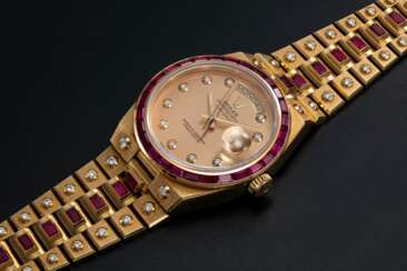 ROLEX. A RARE GOLD OYSTERQUARTZ DAY-DATE, DIAMOND AND RUBY-SET WRISTWATCH AND BRACELET, REF. 19168 