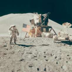 Saluting the flag: Astronaut David Scott performs military salute beside American flag, lunar module "Falcon" and lunar rover, Hadley Delta beyond, July 26-August 7, 1971