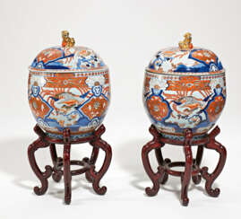 Pair of large lidded Imari jars with phoenix and lion handle