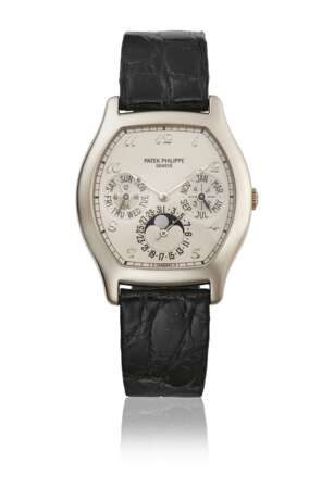 PATEK PHILIPPE. A RARE 18K WHITE GOLD TONNEAU-SHAPED AUTOMATIC PERPETUAL CALENDAR WRISTWATCH WITH MOON PHASES, 24 HOUR AND LEAP YEAR INDICATION, ADDITIONAL CASE BACK, CERTIFICATE OF ORIGIN AND BOX - photo 1