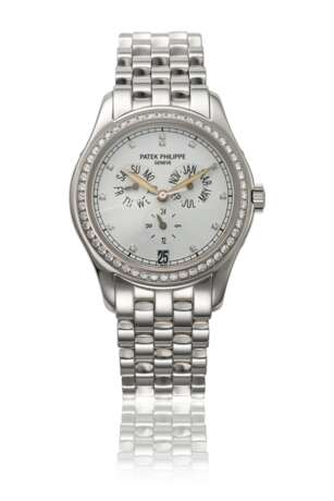 PATEK PHILIPPE. AN 18K WHITE GOLD AND DIAMOND-SET AUTOMATIC ANNUAL CALENDAR WRISTWATCH WITH SWEEP CENTRE SECONDS, DATE, DAY AND NIGHT INDICATION, BRACELET, CERTIFICATE OF ORIGIN AND BOX - photo 1