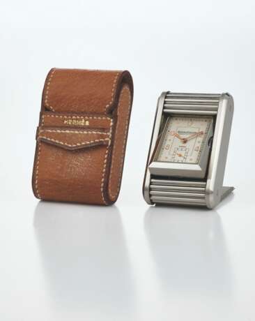 JAEGER-LECOULTRE, RETAILED BY HERMES. A RARE AND UNUSUAL STAINLESS STEEL TRAVEL TIMEPIECE WITH SLIDING COVER - photo 1