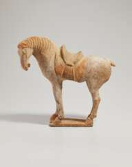 A CHINESE PAINTED RED POTTERY MODEL OF A SADDLED HORSE