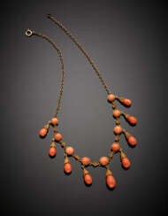 Yellow 9K gold chain necklace with nine graduated pinkish orange coral pendants