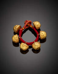Bracelet formed by six carved yellow gold and tar bead with cloth strap
