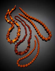 Lot comprising four necklaces in part graduated of which two are heated amber and two in resin