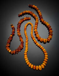 Lot comprising three graduated bead and half bead amber necklaces