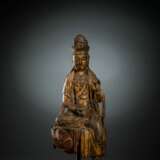 Feine und seltene Holzfigur des Guanyin auf einem Lotos mit Vergoldung und Resten von Fassung - фото 1