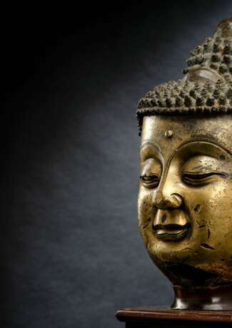 Großer feuervergoldeter Kopf des Buddha aus Bronze auf einem Holzstand - photo 2