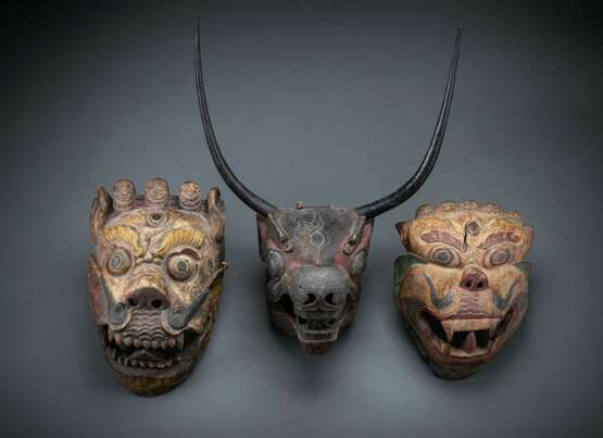 Drei gefasste Masken aus Holz, darunter Dämonenmaske und Maske mit langen Hörnern - Foto 1
