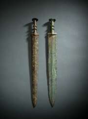 Zwei Schwerter aus Bronze, partiell grün korrodiert, Holzstände