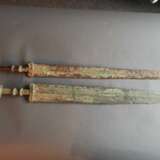 Zwei Schwerter aus Bronze, partiell grün korrodiert, Holzstände - Foto 3