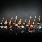 Satz von 26 Miniatur-Musikinstrumenten aus verschiedenen Steinen wie Achat und Malachit gearbeitet, Holzstände, Stoffbox - фото 1