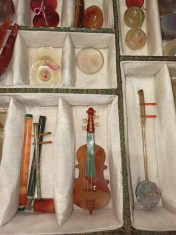 Satz von 26 Miniatur-Musikinstrumenten aus verschiedenen Steinen wie Achat und Malachit gearbeitet, Holzstände, Stoffbox - photo 3