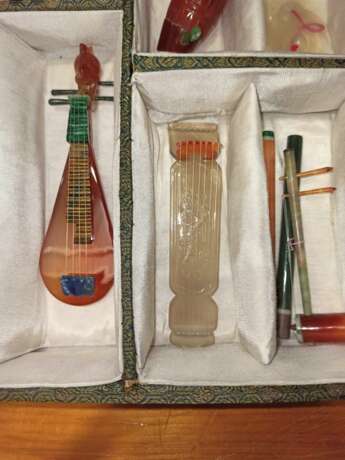 Satz von 26 Miniatur-Musikinstrumenten aus verschiedenen Steinen wie Achat und Malachit gearbeitet, Holzstände, Stoffbox - photo 5