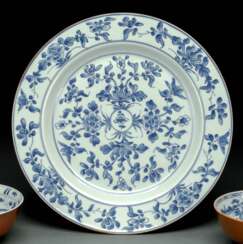 Unterglasurblau dekorierter großer Teller aus Porzellan mit Dekor von Päonien und anderen Blüten mit braunem Rand
