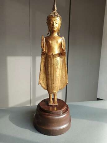 Lackvergoldete Bronze des stehenden Buddha Shakyamuni auf einem Holzsockel - photo 2