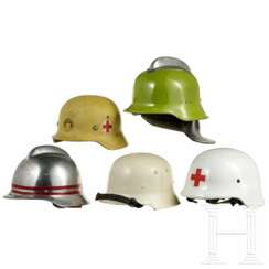 Fünf internationale Helme Feuerwehr, Rotes Kreuz, Zivilschutz, 1950er - 1990er