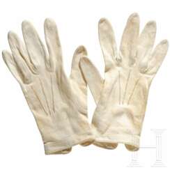 Ein Paar weiße Handschuhe zum Ausgehanzug