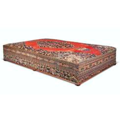 AN ENGLISH CARPET-COVERED STAINED-PINE LARGE OTTOMAN