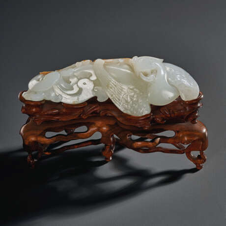 A WHITE AND RUSSET JADE CARVING OF A RECUMBENT PHOENIX - photo 1