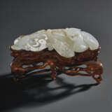 A WHITE AND RUSSET JADE CARVING OF A RECUMBENT PHOENIX - photo 1