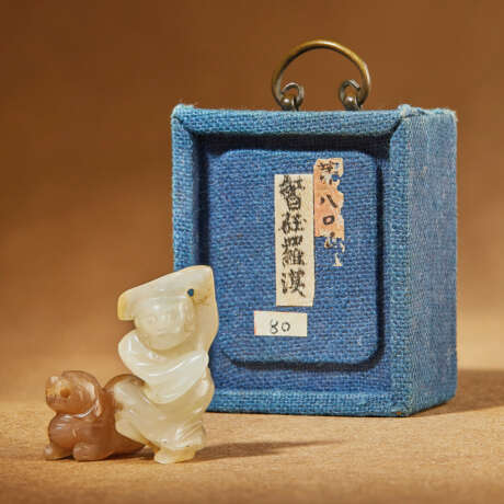 A MINIATURE WHITE AND BROWN JADE FIGURE OF A FOREIGNER AND BUDDHIST LION - Foto 1
