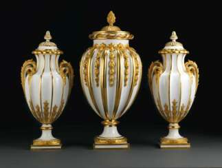 A SEVRES (HARD PASTE) PORCELAIN GARNITURE OF THREE GILT-WHITE RIBBED VASES AND COVERS