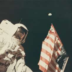 ASTRONAUT HARRISON SCHMITT WITH THE EARTH ABOVE THE US FLAG, DECEMBER 7-19, 1972