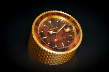 ROLEX, A GILT METAL QUARTZ DESK CLOCK WITH DEAD CENTER SECONDS AND DATE