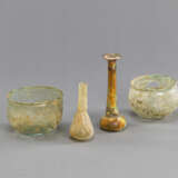 Vier antike Glasgefäße aus grünlichem Glas, teils versintert. Darunter zwei Balsamarien und zwei kleine Schalen - photo 1
